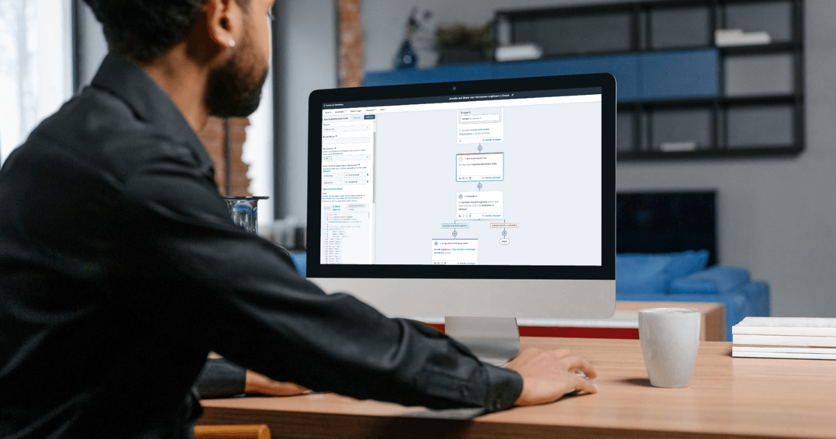 Mann bearbeitet HubSpot Custom Code Workflow Action am Computer.